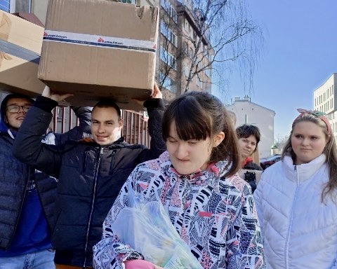 na zdjęciu: uczniowie niosą pudła kartonowe z darami dla Ukraińców
