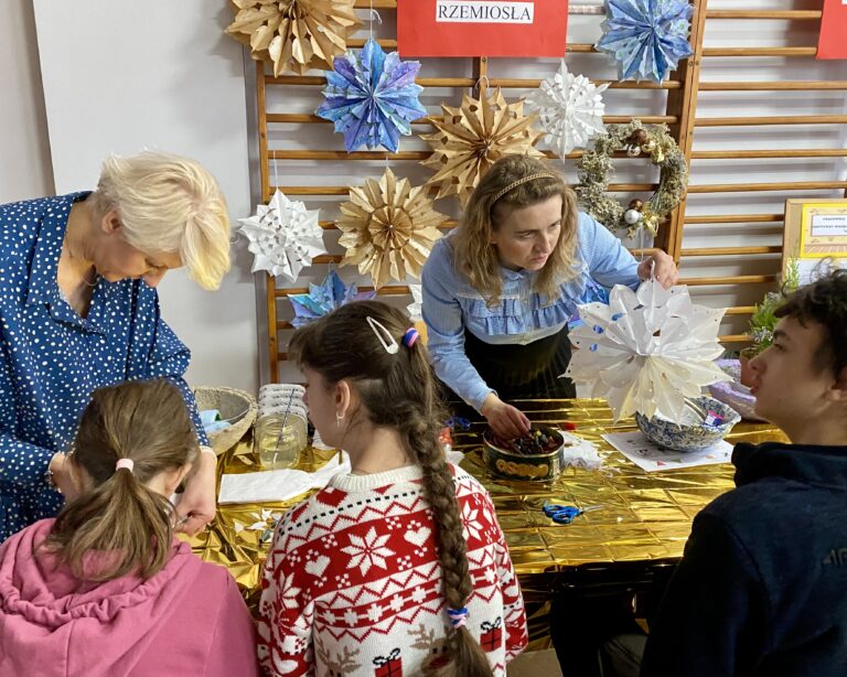 Na zdjęciu uczestnicy warsztatów świątecznych wykonują papierowe gwiazdy